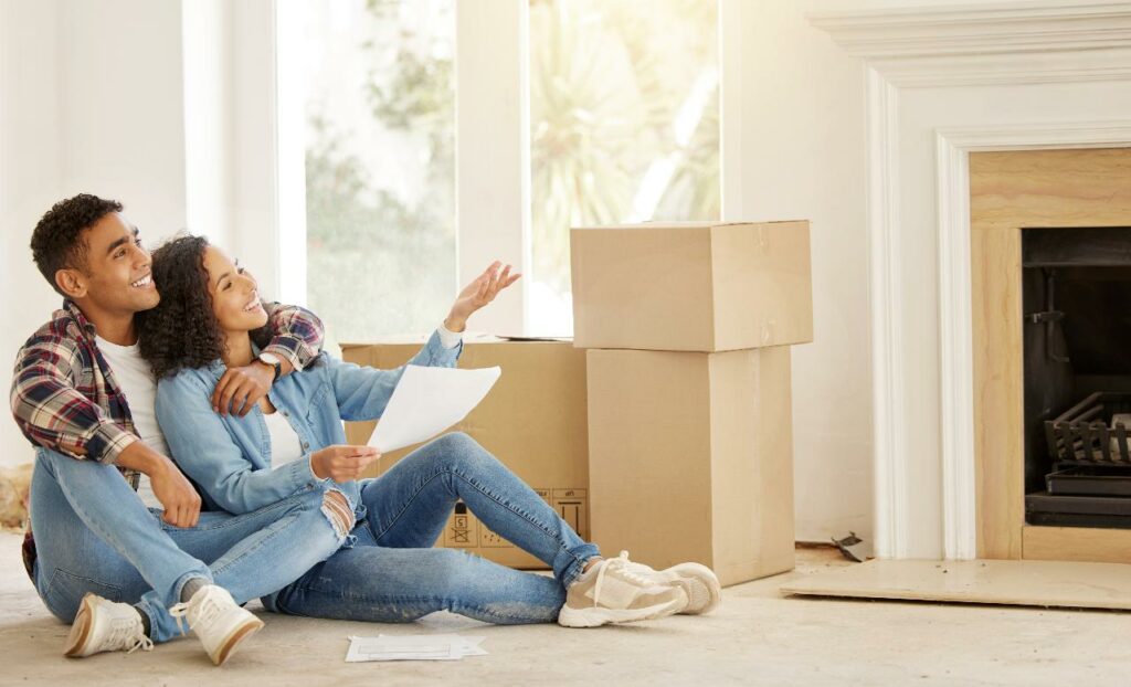 A young couple with moving boxes going over renovation plans