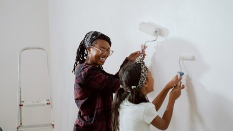 A mother and daughter painting a wall