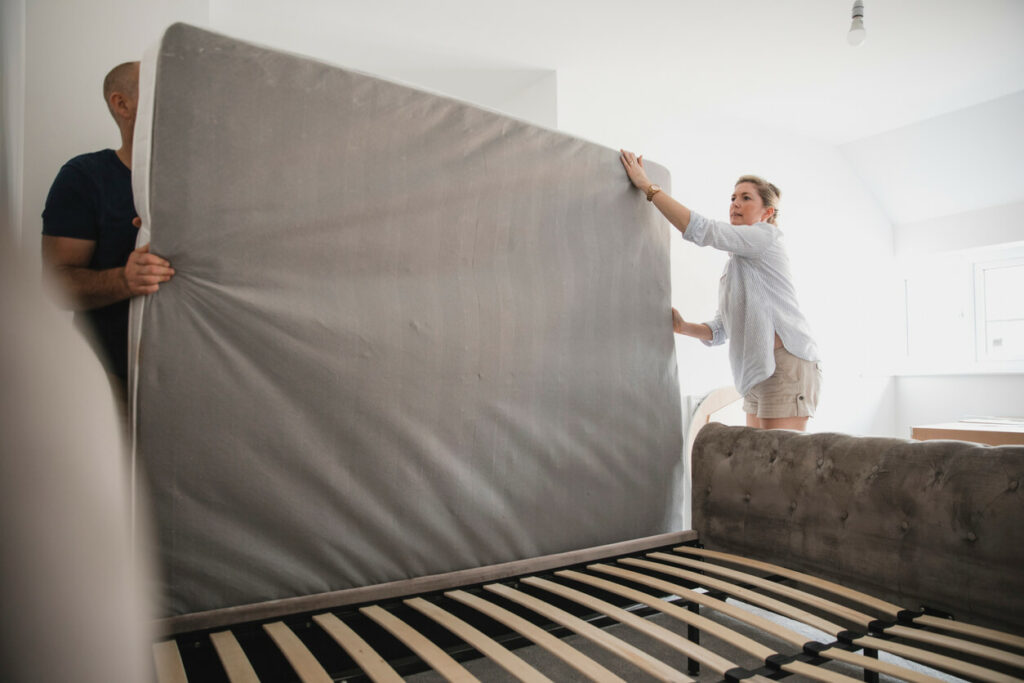 Couple sets up their new bed during their bedroom makeover.