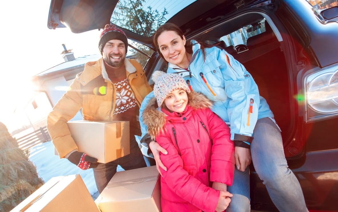 Family packing their car as they move to a new home in the winter.