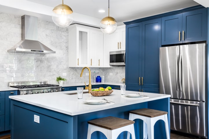 Organized kitchen with blue cabinets and white countertops.