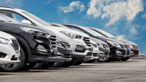 Black, silver, and white cars arranged in a row in a lot
