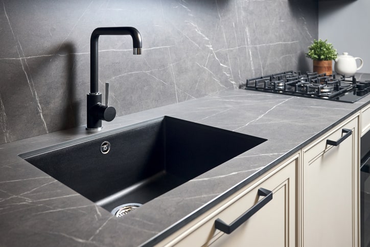 Black, brushed metal kitchen sink is sanitary and ready for use.