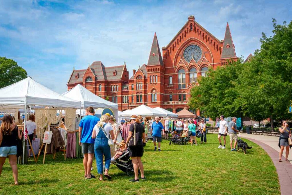 A view of Cincinnati Music Hall from Washington Park with many people during a Craft Fair.